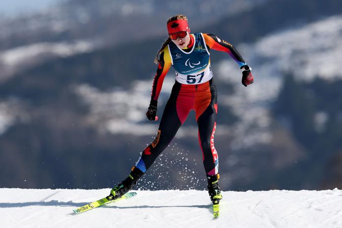A female Para biathlon athlete is competing in the skiing segment